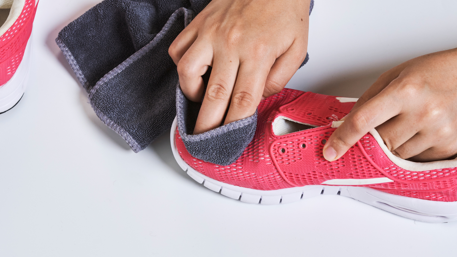 Person cleaning their running shoes so that they will last longer
