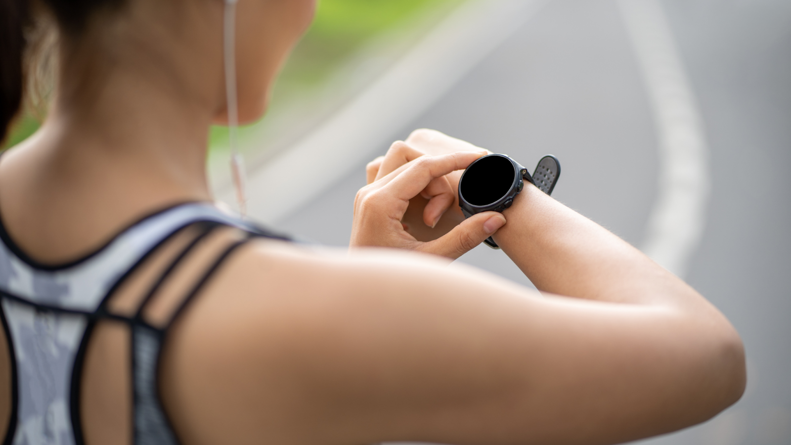 Woman turning her smartwatch on before she sets off on a run