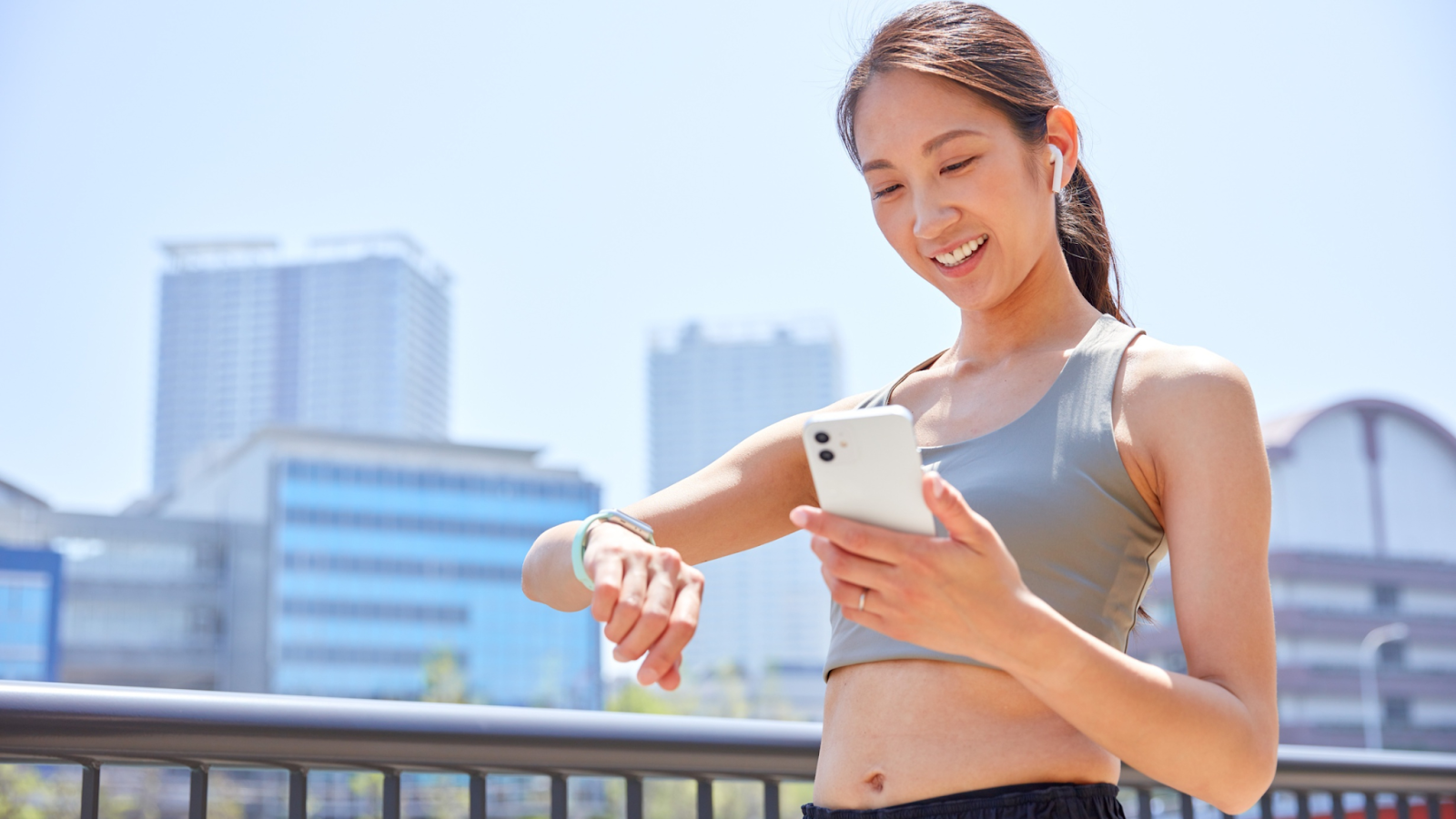 Woman tracking her running speed on her phone and watch