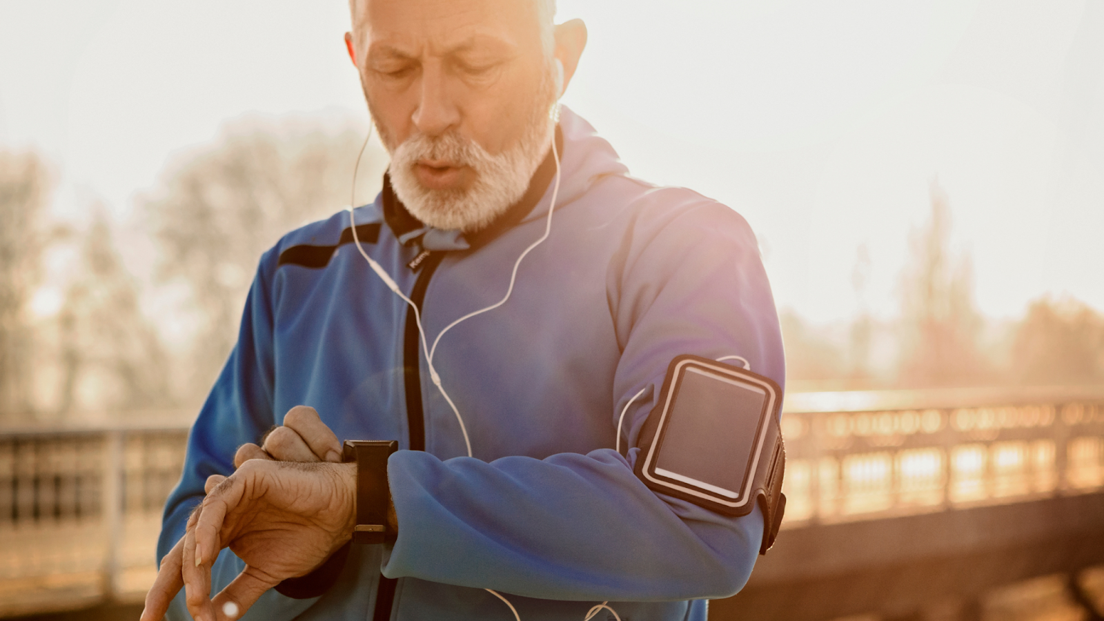 Man setting off for a run and turning on his smart watch to pace himself