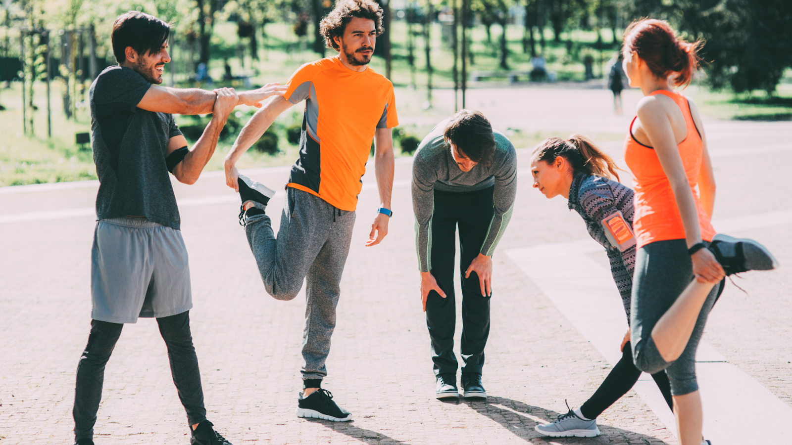 Group of beginner runners warming up through various stretches