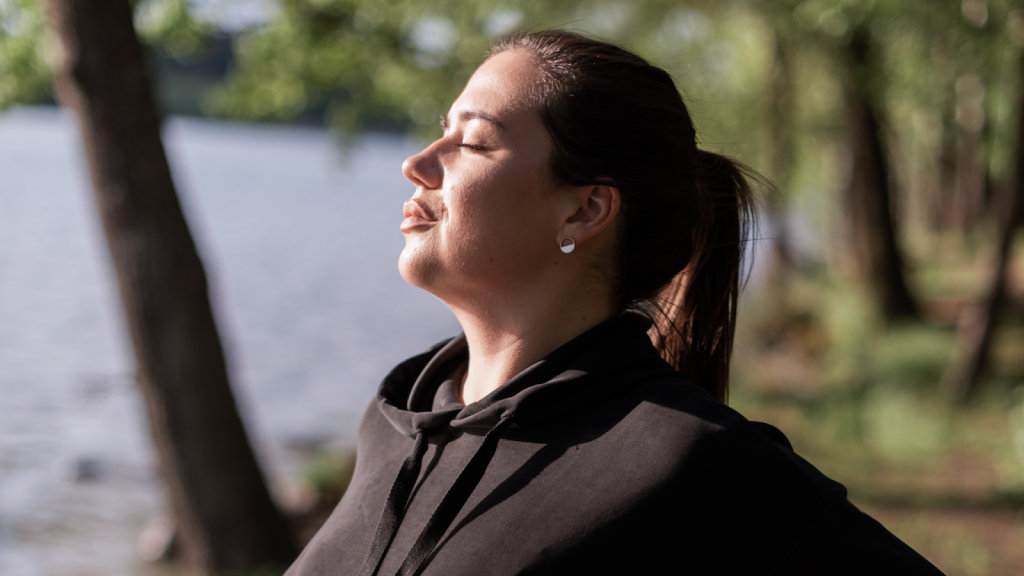 Woman focusing on her breathing whilst exercising outside