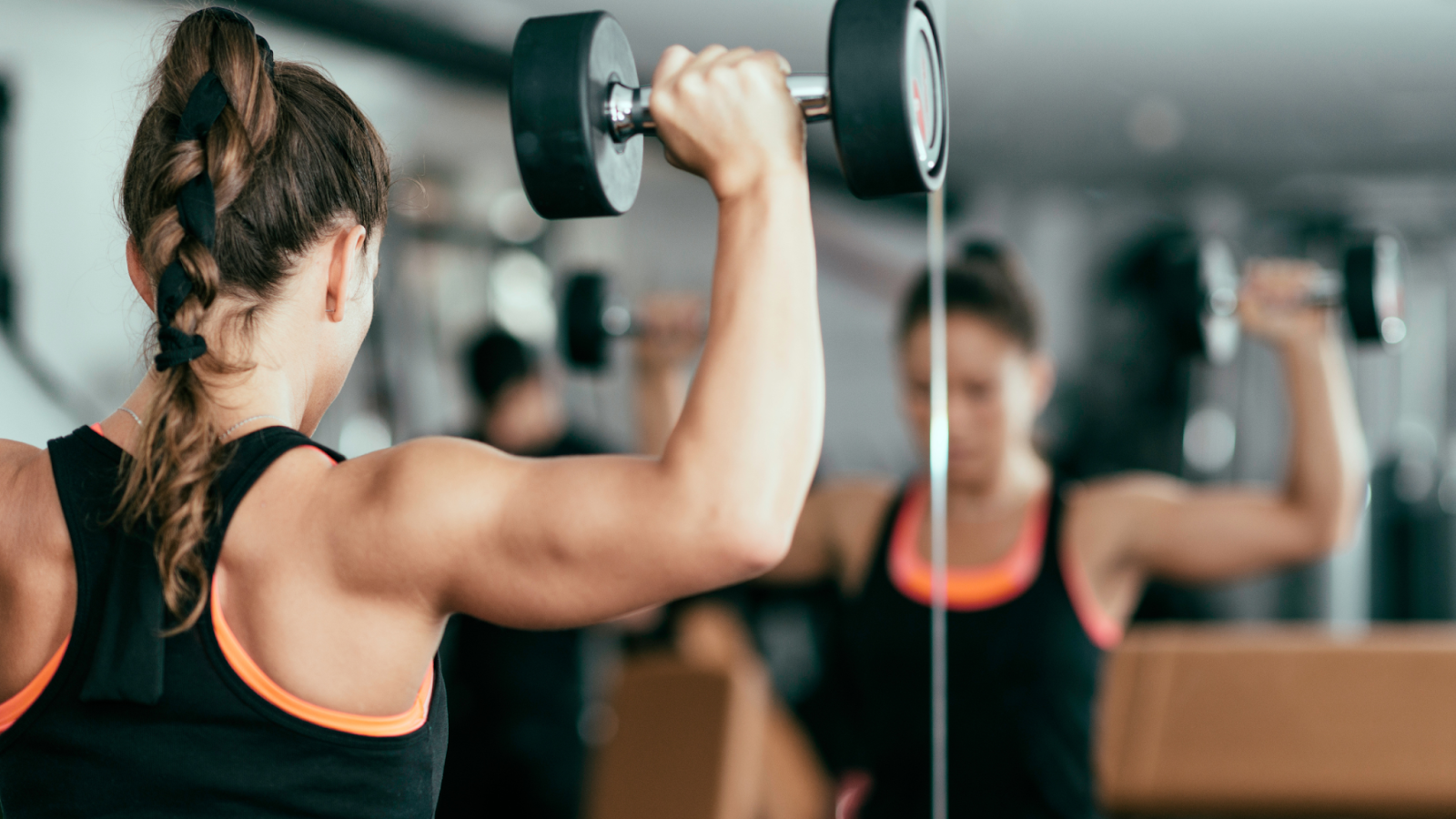 Woman building her arm strength by exercising with weights