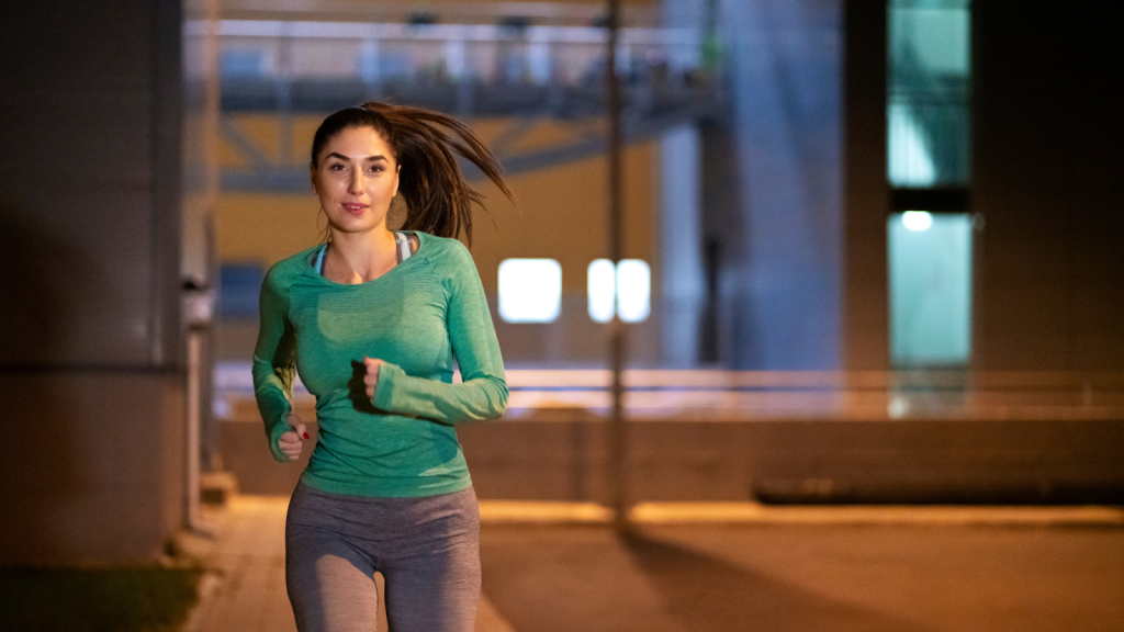 A happy woman in her running gear, running in the streets