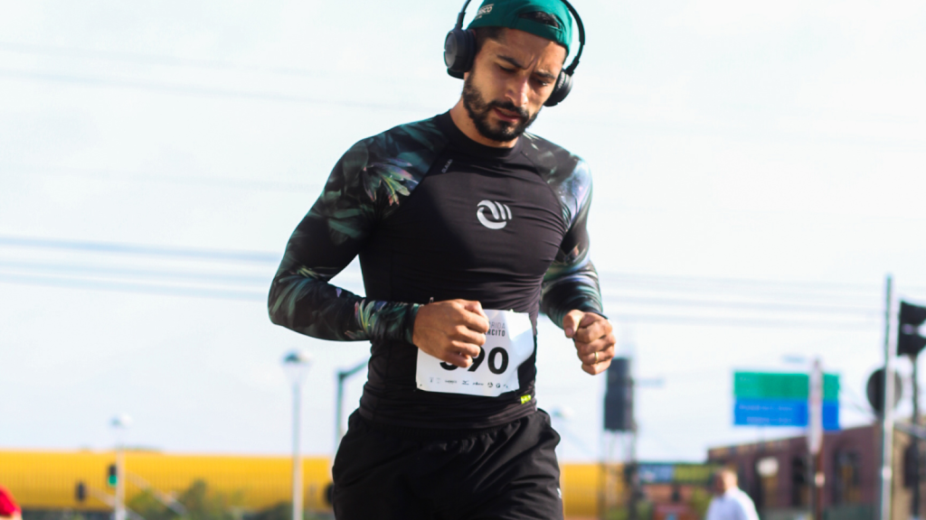 Man running a race with muscles built from his training