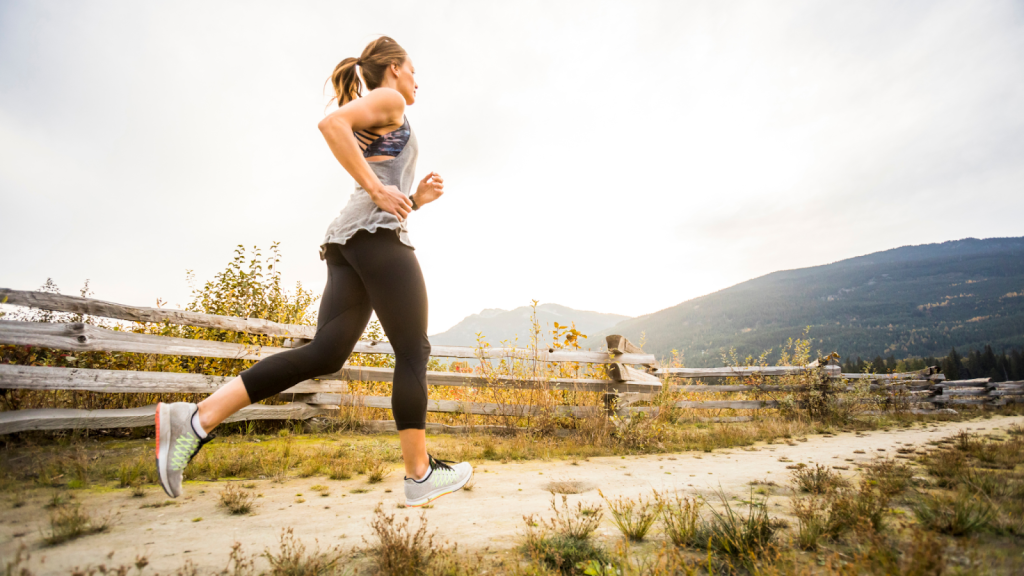 Woman running outside with mountains in the background