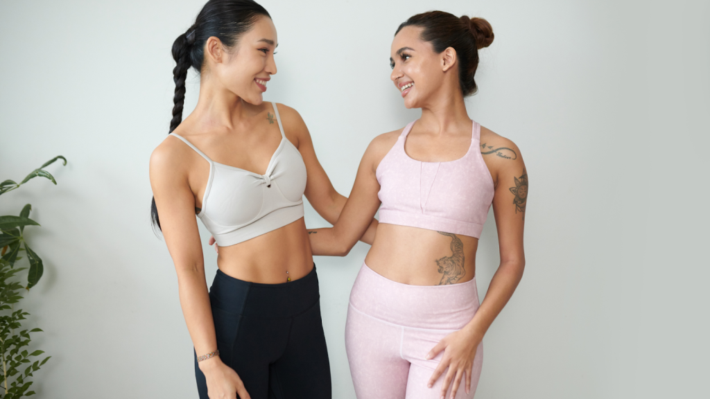 Two women in sports gear wearing supportive sports bras