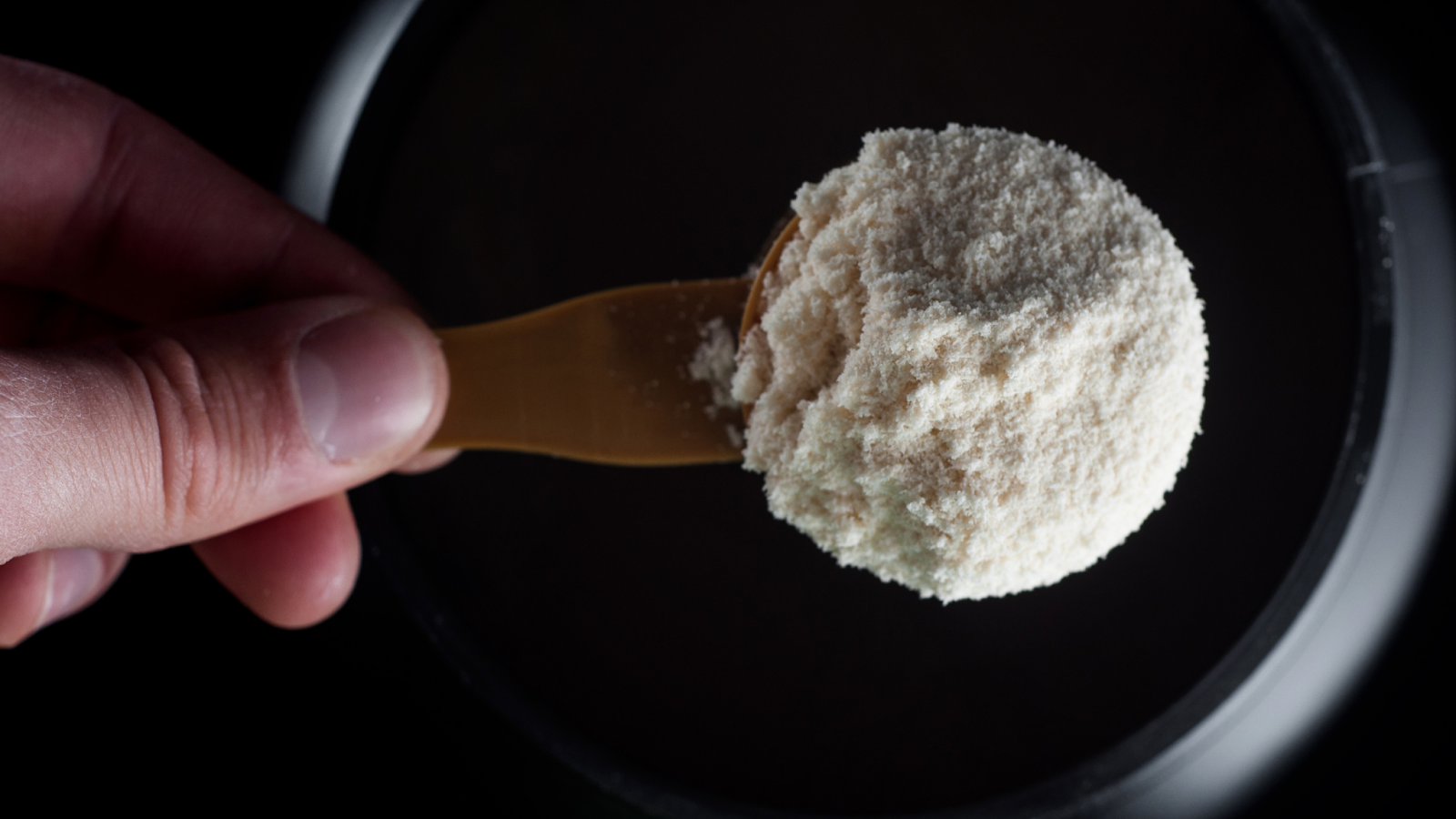 person taking a spoon full of creatine