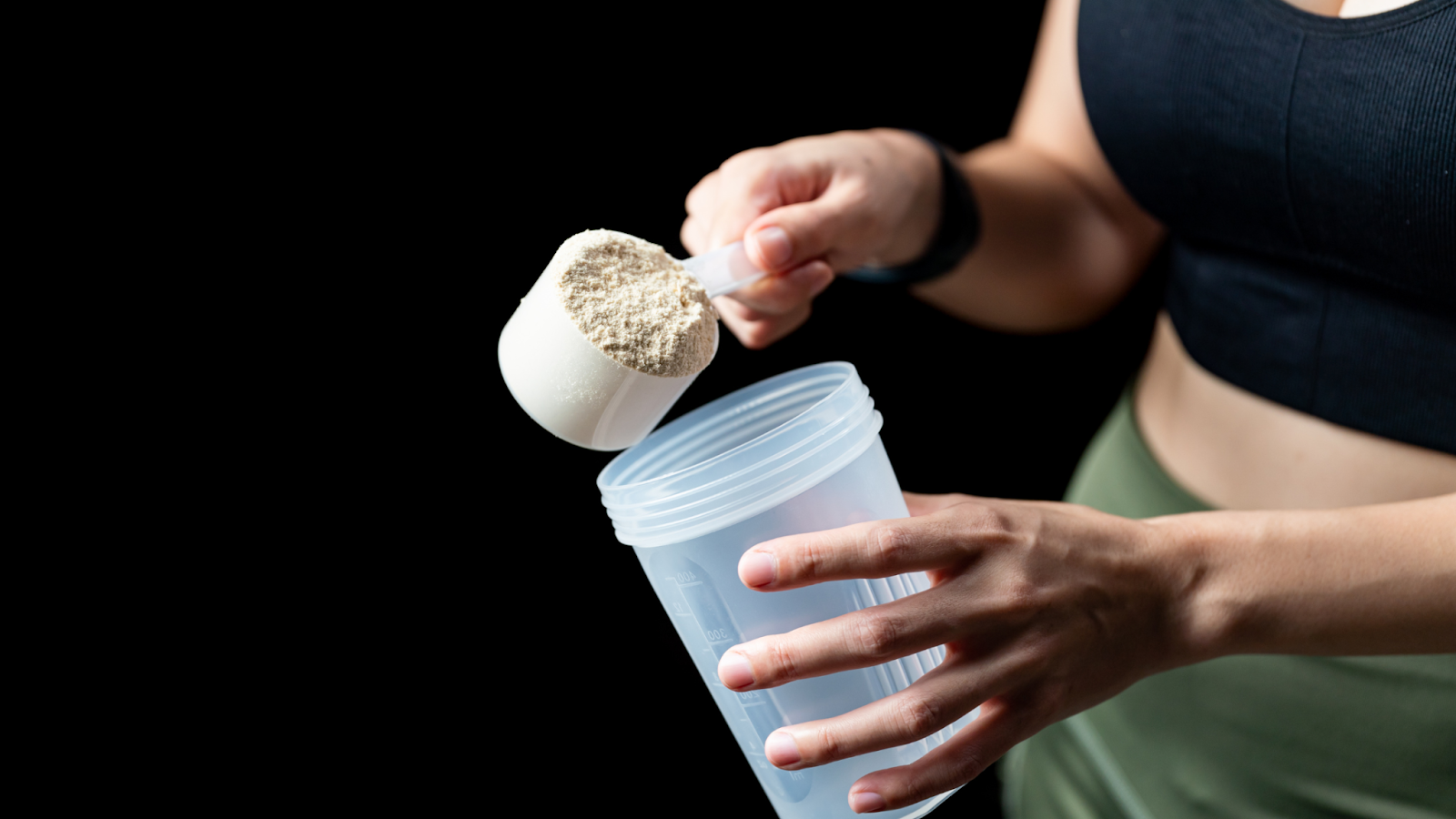 Woman preparing a creatine drink before her workout