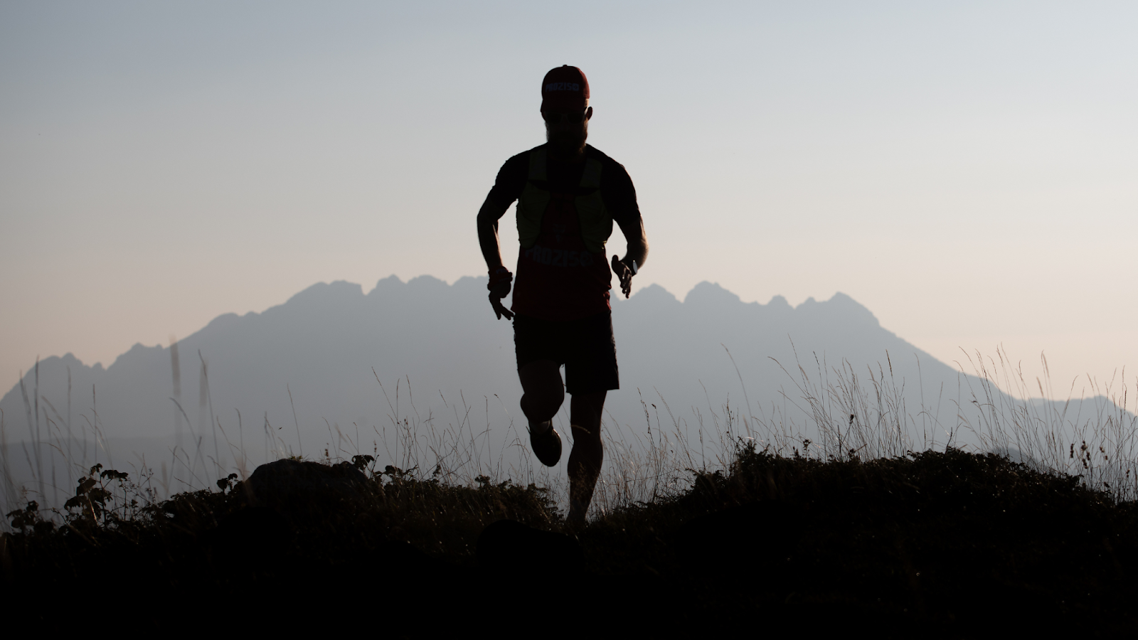 Man running outside with mountains in the background